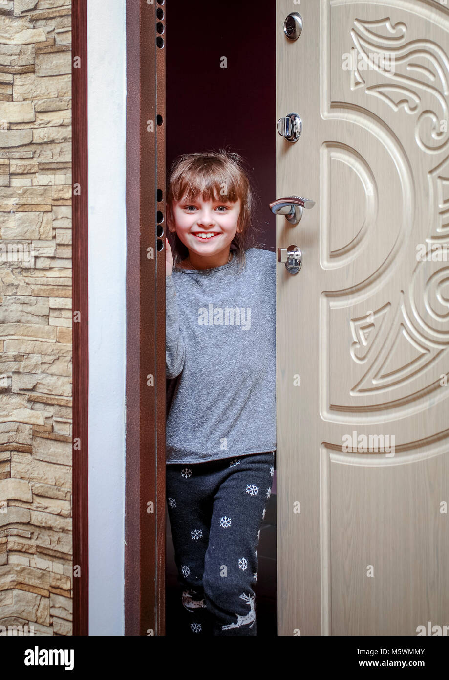 Un poco alegre niña llega a casa, abre la puerta y sonrisas Fotografía de  stock - Alamy
