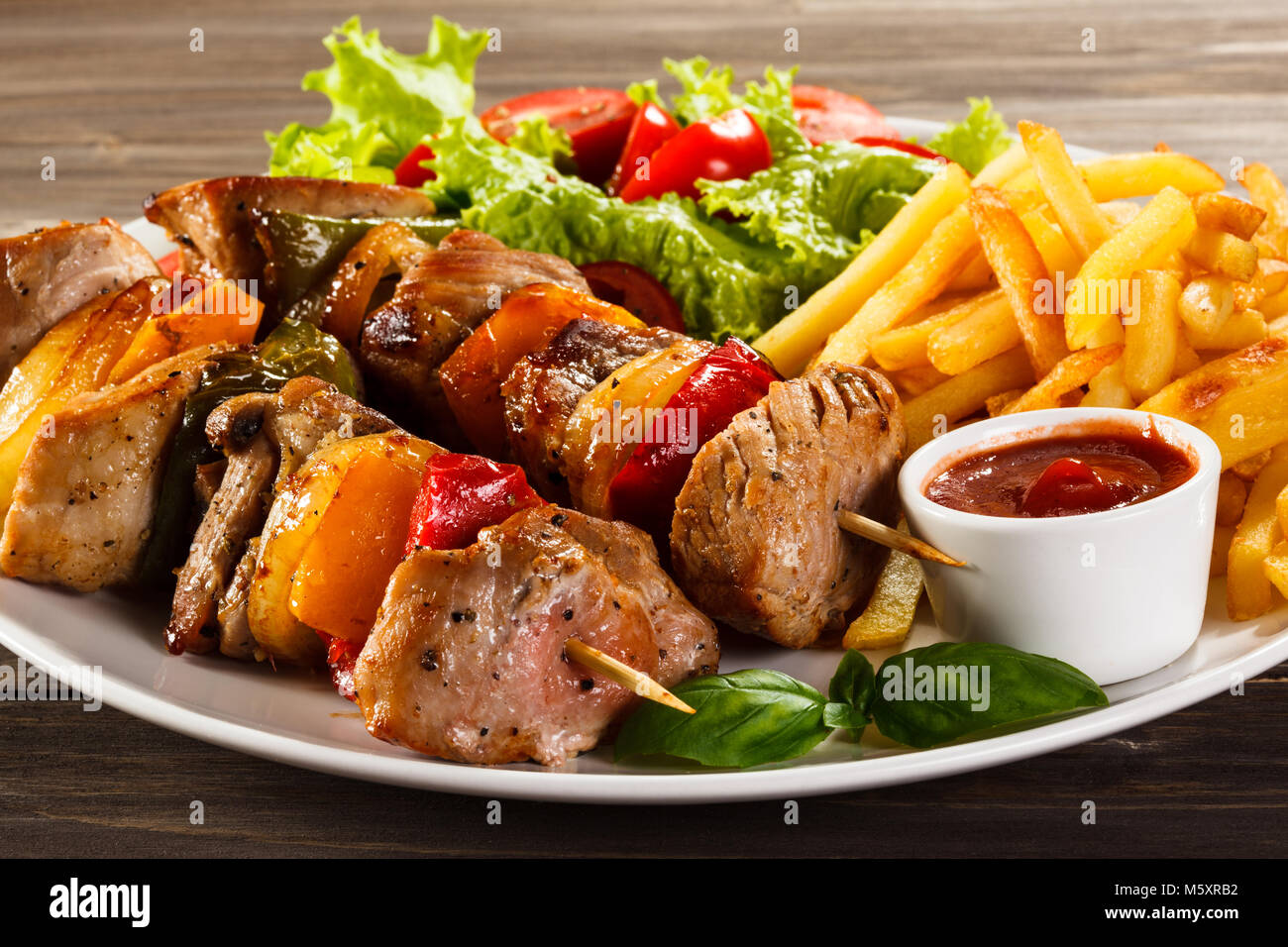 kebab-carnes-y-verduras-en-mesa-de-madera-m5xrb2.jpg