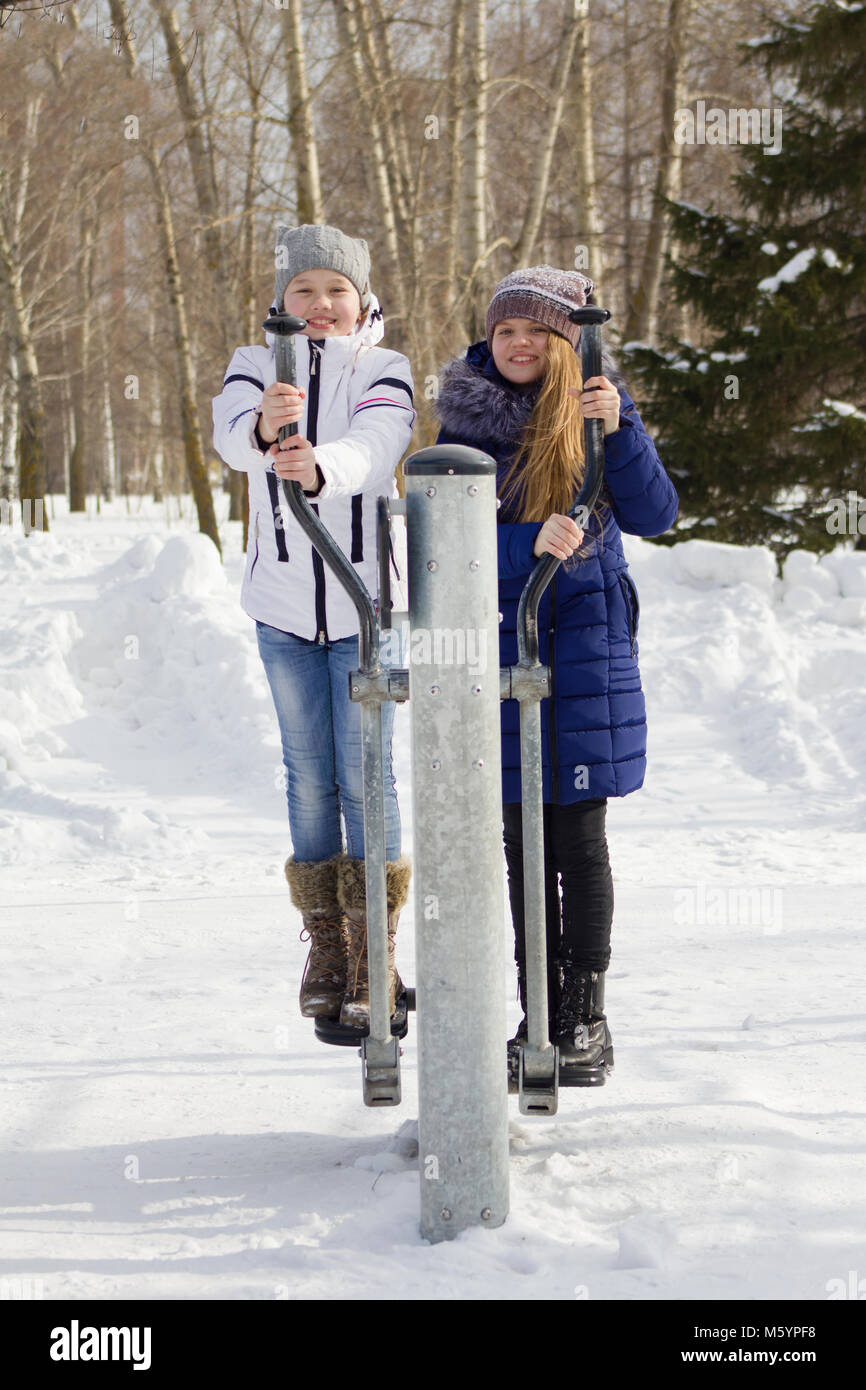 chicas en ropa de abrigo y andar jugando afuera en el invierno Fotografía stock - Alamy