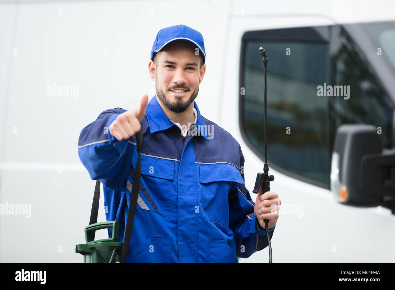 Retrato de un sonriente macho Trabajador de Control de Plagas de pie en la parte delantera del vehículo Foto de stock