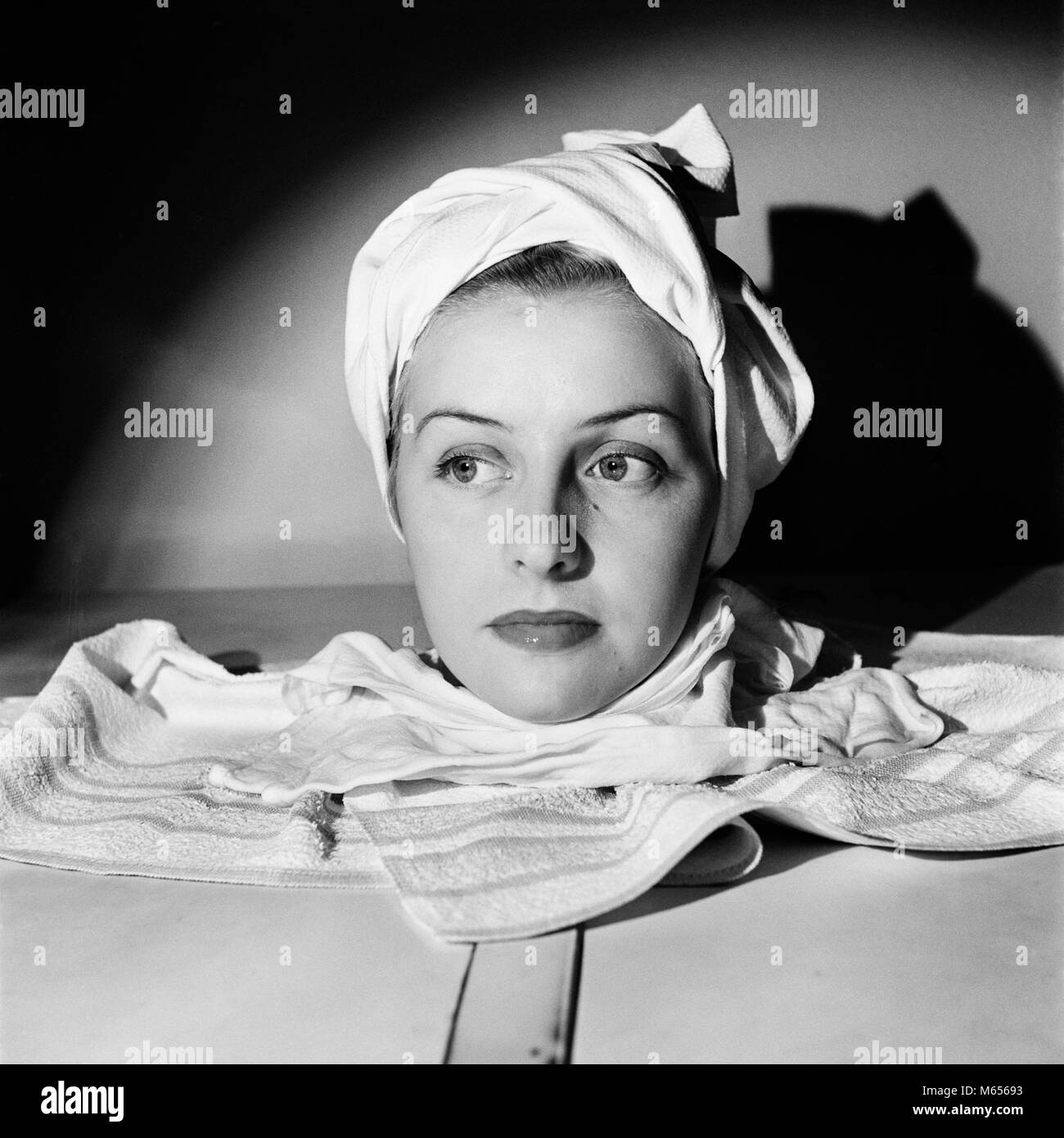 1950 Retrato de mujer cabeza disparado en spa relajante sauna de vapor gabinete toalla envuelta alrededor de la cabeza - c3609 HAR001 HARS adulto joven mujer B&W BLANCO Y NEGRO la etnia CAUCÁSICA ANTICUADO PERSONAS SAUNA Foto de stock