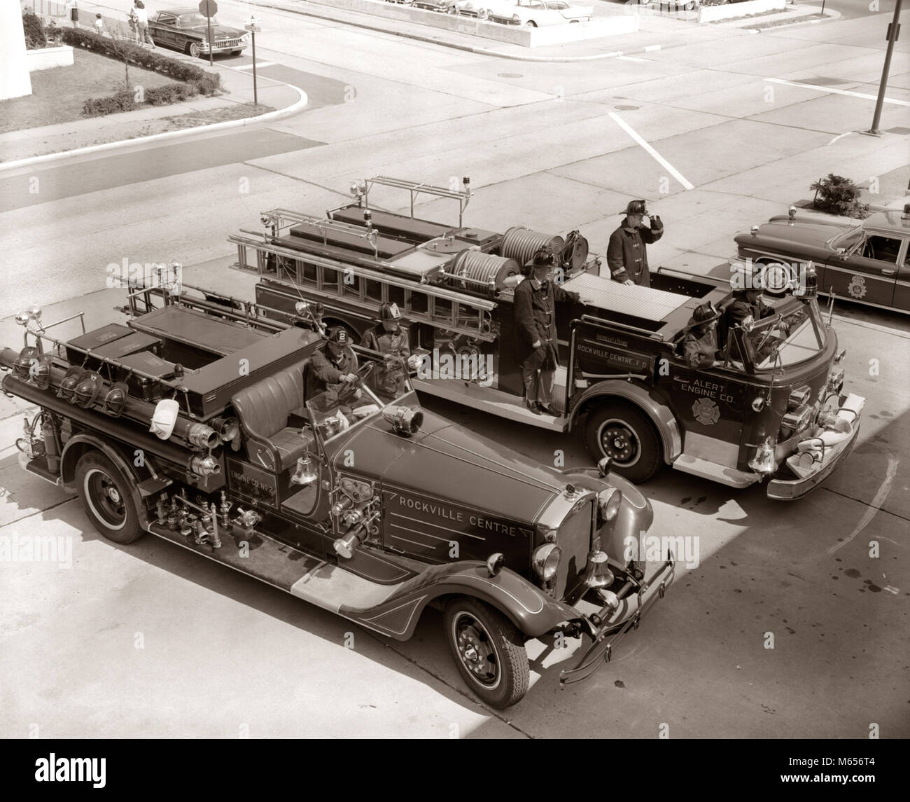 1960 VISTA SUPERIOR DE dos camiones de bomberos estacionado en la estación de bomberos en el camión usando equipo de protección - F440 HAR001 HARS estacionarse camiones bombero desastre ocupación alto