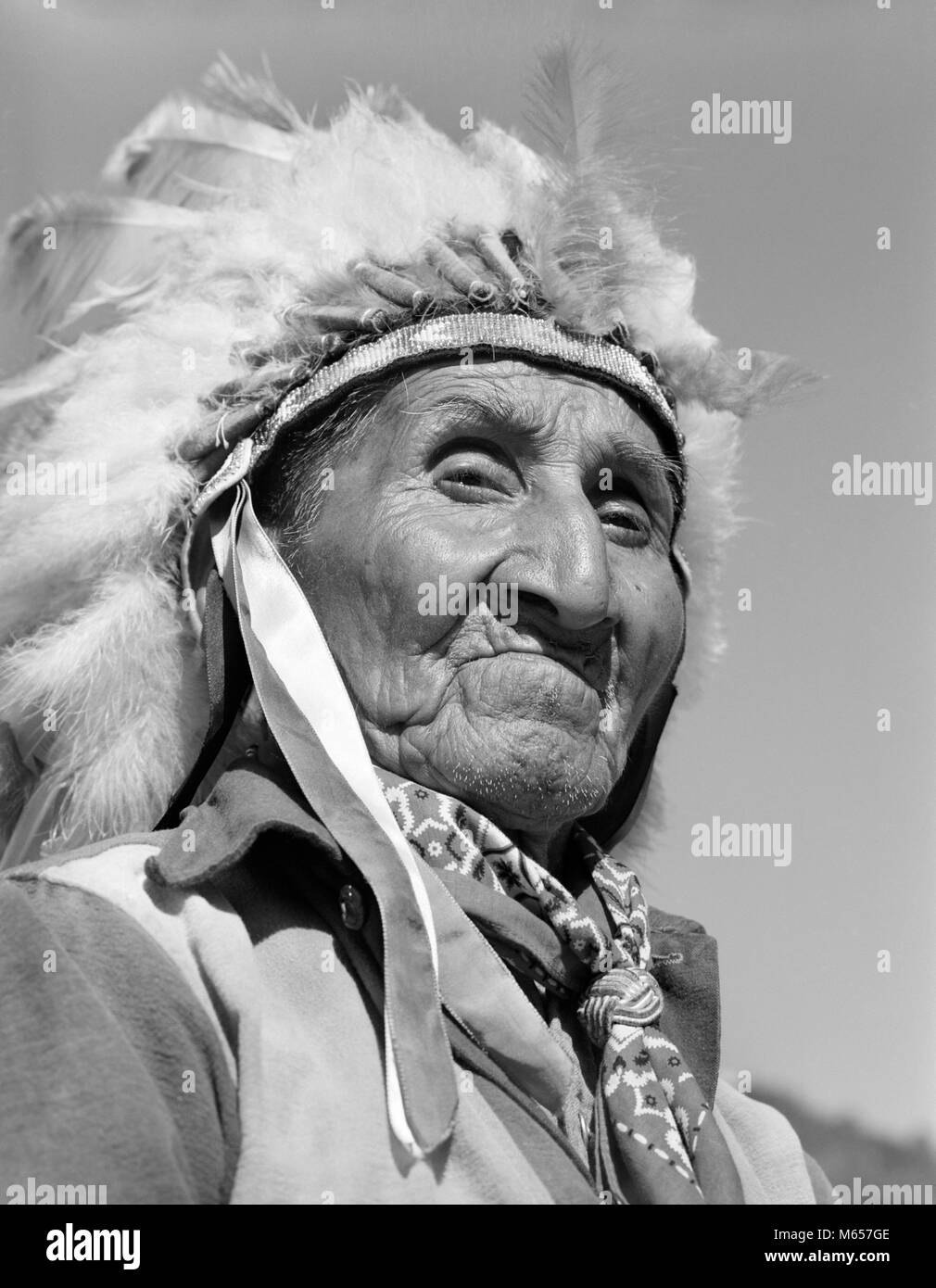 1950 1960 Retrato Native American indios Cherokee altos hombre que llevaba un tocado de plumas mirando a la cámara CAROLINA DEL NORTE EE.UU. - i1477 CRS001 HARS CRECIDOS, ESTADOS UNIDOS DE AMÉRICA PERSONAJE HOMBRE SENIOR ADULTO SENIOR NOSTALGIA NORTEAMÉRICA contacto ocular 60-65 años pueblo norteamericano, historia de cabeza y hombros fuerza aventura liderazgo orgullo jefe competente CAROLINA 70s adulto East Coast War Bonnet tocado nativos americanos varones conflictivos NC North Carolina B&W un pañuelo blanco y negro DESAPROBANDO CHEROKEE mirando a la cámara indígena NOBLE ANTIGUO PERSONAS GRAVES Foto de stock