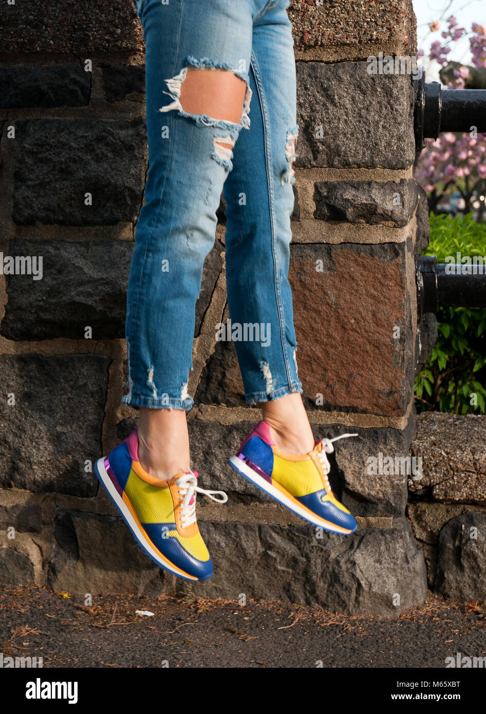 Imagen de moda cerca de los pies de la mujer, vestido con jeans y zapatillas  brillantes elegante Fotografía de stock - Alamy