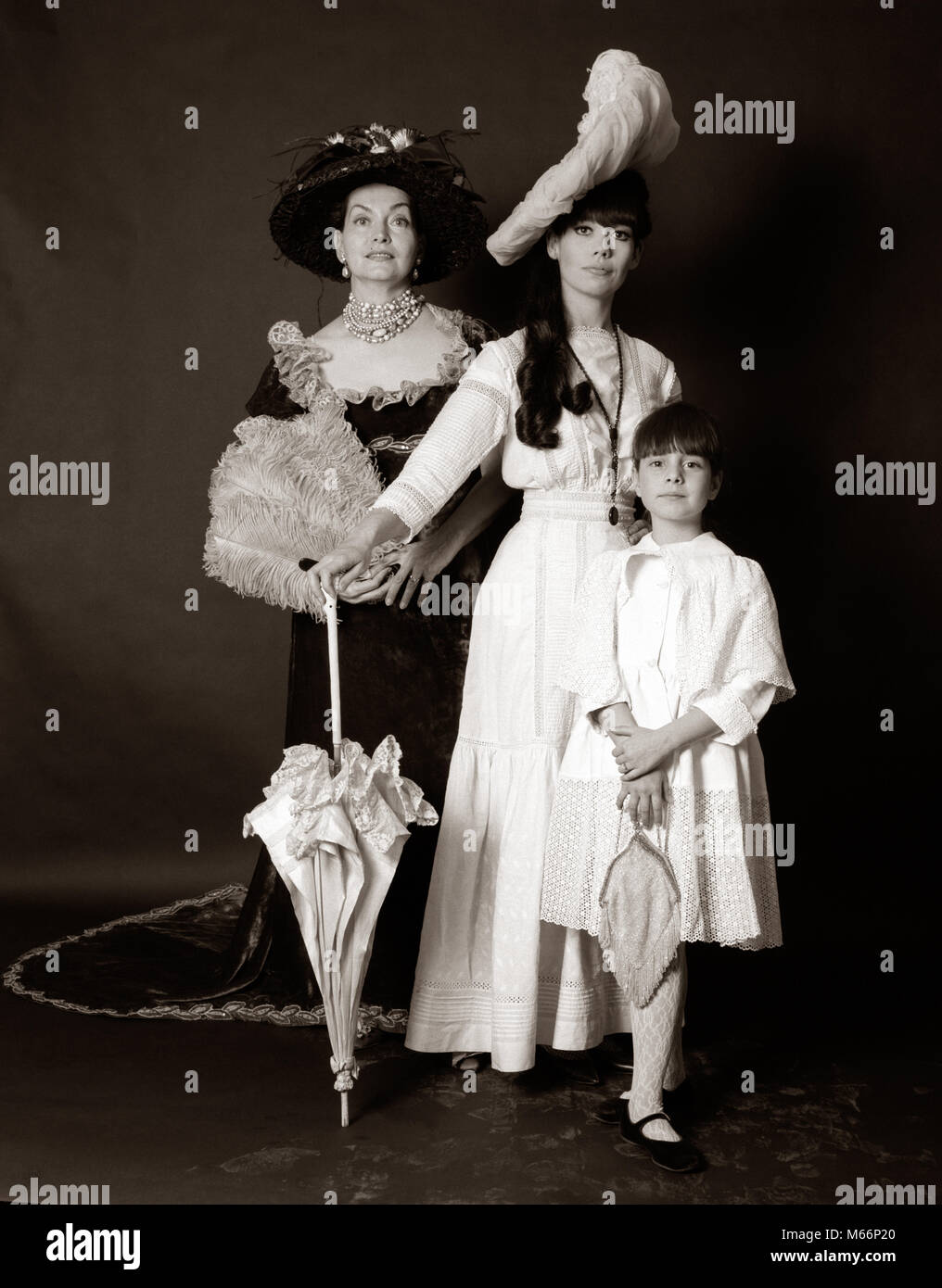 1960 tres generaciones de mujeres abuela Madre Hija planteados de pie mirando a la cámara luciendo vestidos de moda 1890 - s3311 HAR001 HARS STUDIO SHOT PERSONA DE LONGITUD COMPLETA DE CARÁCTER 1960 tres generaciones de mujeres abuela Madre Hija planteados de pie mirando a la cámara luciendo vestidos de moda 1890 - s3311 HAR001 HARS STUDIO SHOT PERSONA DE LONGITUD COMPLETA DE CARÁCTER