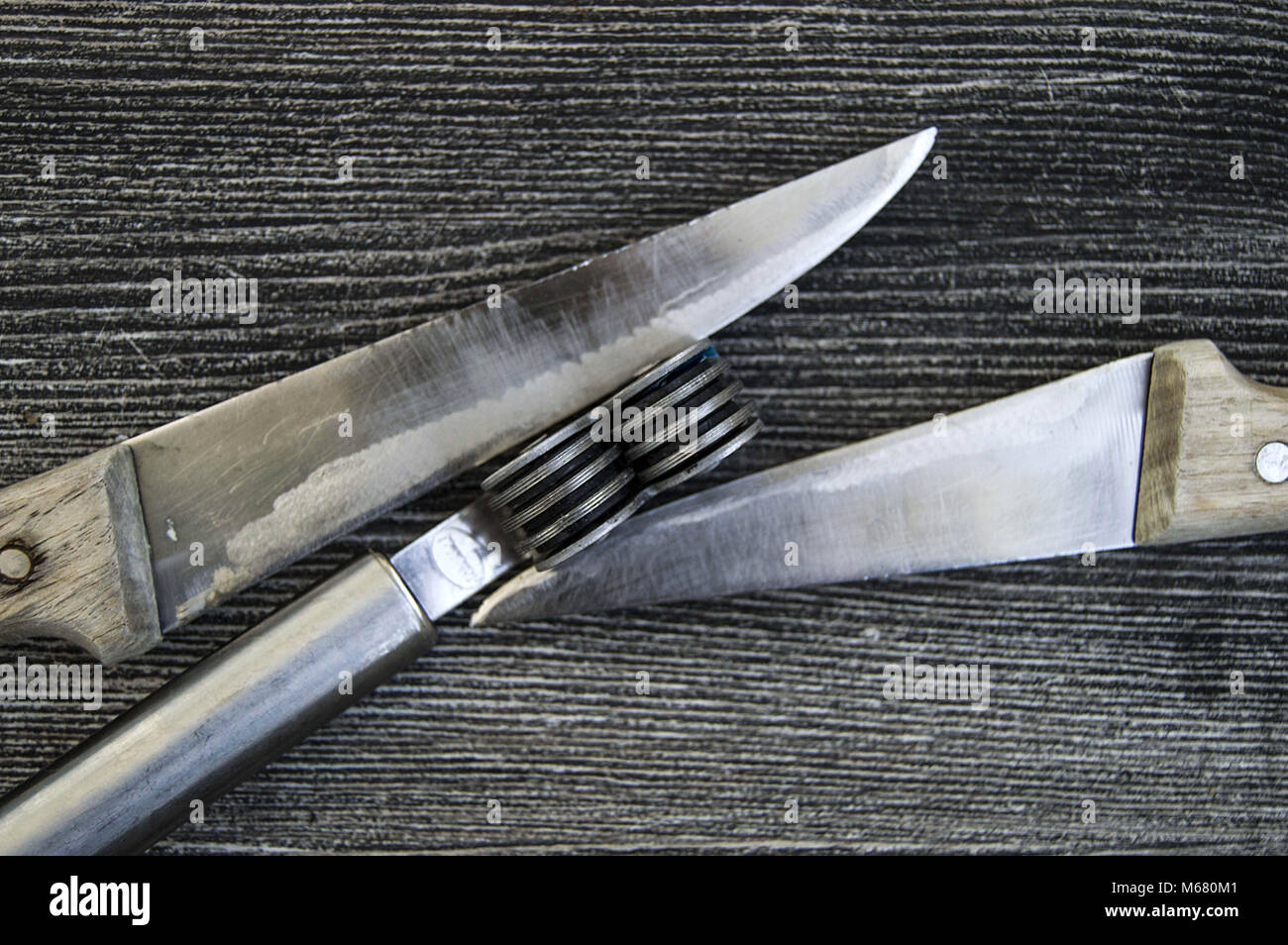 https://c8.alamy.com/compes/m680m1/las-cuchillas-se-erige-junto-a-la-hoja-de-molienda-herramienta-de-afilado-de-cuchillas-cuchillas-romas-afilado-con-herramientas-de-afilado-pulido-m680m1.jpg
