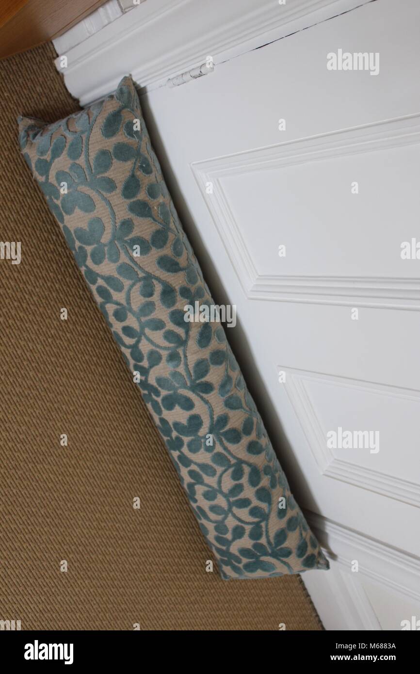Turquesa y crema deflector contra una puerta de chapa blanca sobre una alfombra de color arena Foto de stock
