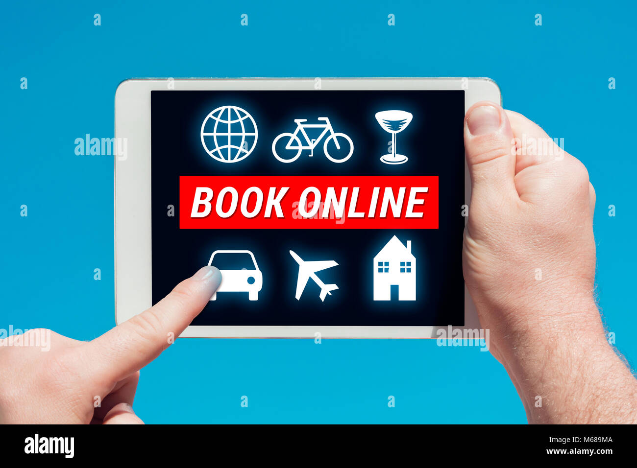 Hombre sujetando un dispositivo tablet con reserva online concepto, tocar la pantalla con un dedo con el cielo azul de fondo. Foto de stock