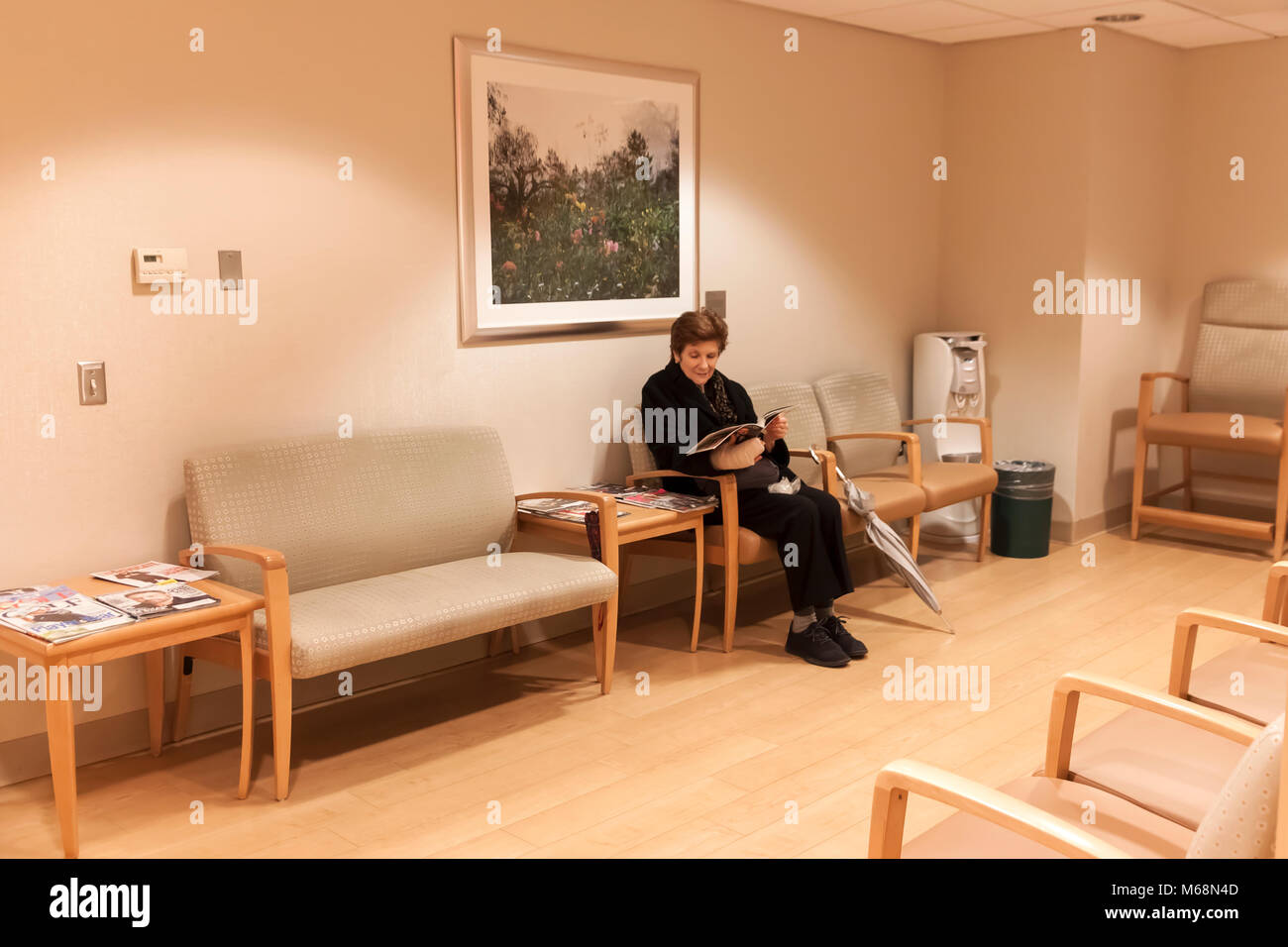 Mujer sentada en la sala de espera de un consultorio médico. Foto de stock