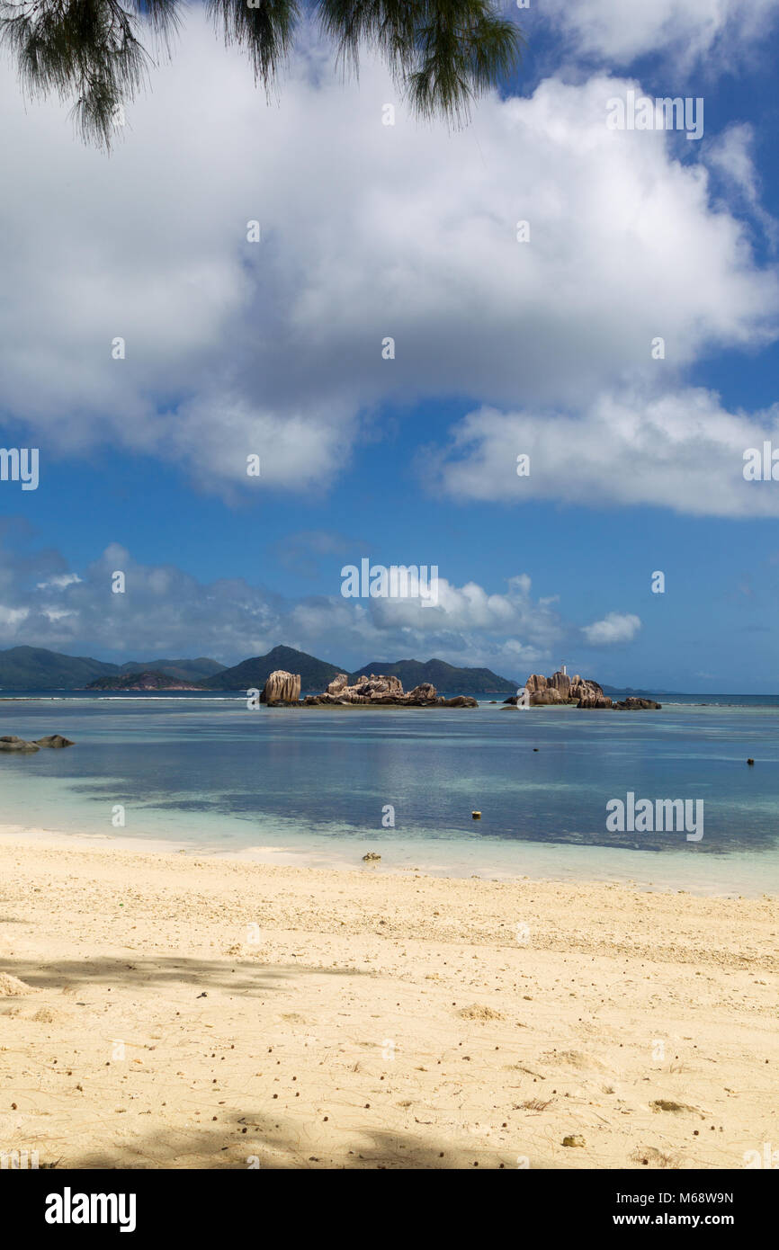 Solitaria playa tropical en La Digue, Seychelles, con vista hacia la vecina isla Praslin. Foto de stock