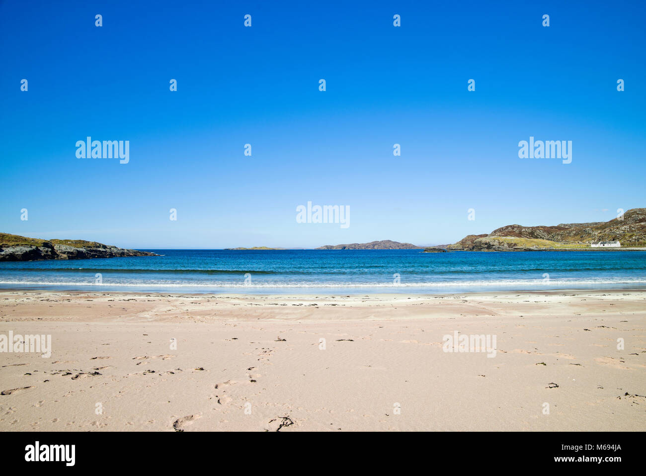 Cielo azul profundo y un mar tranquilo, en la hermosa playa de arena en Assynt Clashnessie Bay, en la costa norte, Ruta 500, Sutherland, Tierras Altas de Escocia en el Reino Unido. Foto de stock