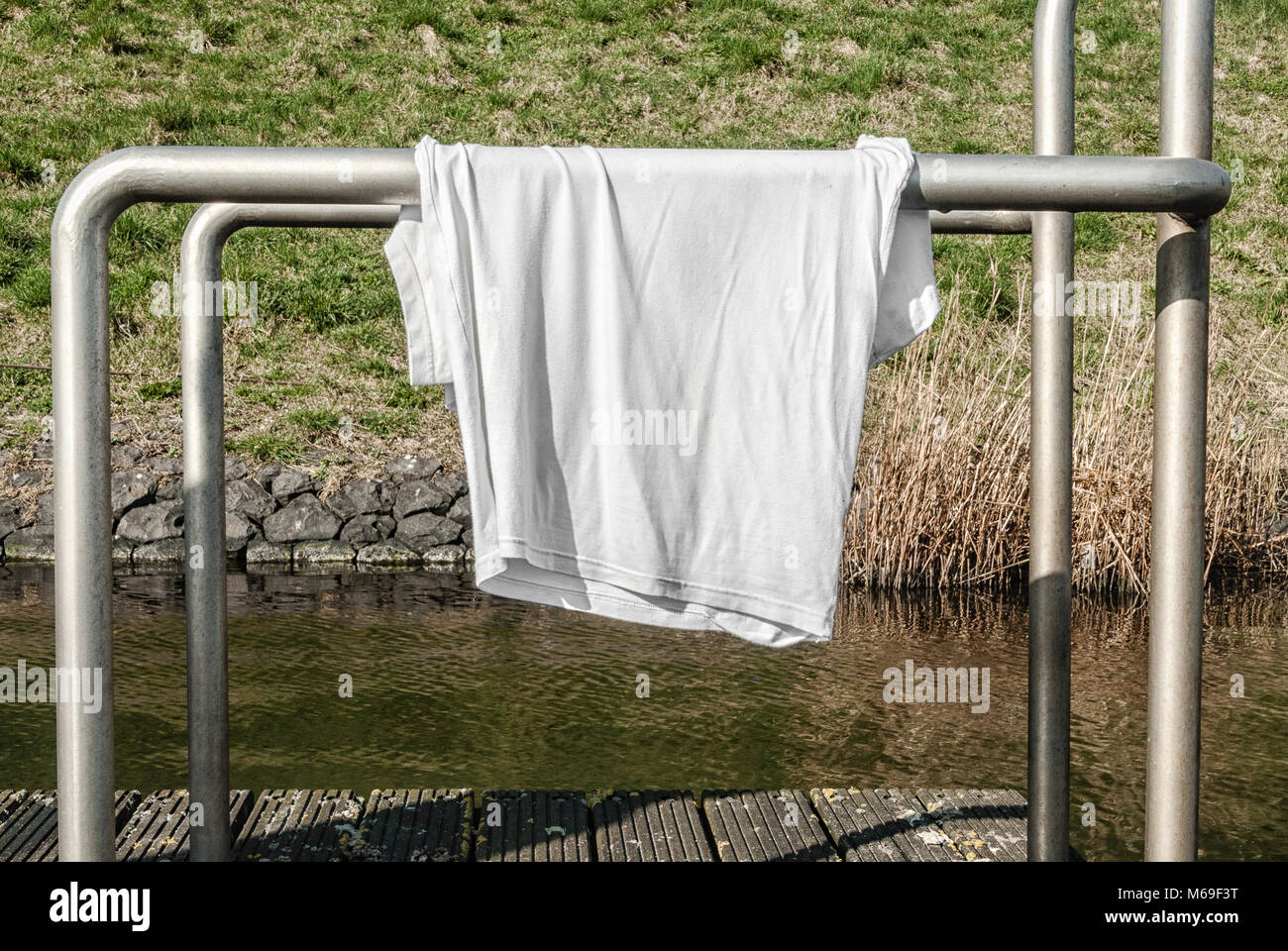 Camisa blanca colgando sobre un tubo de aluminio para secar Fotografía de  stock - Alamy