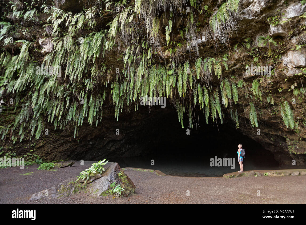 Mujer de pie delante de la Gruta Maraa, cueva, gruta, helechos, Taravao, Tahití, Polinesia Francesa Foto de stock