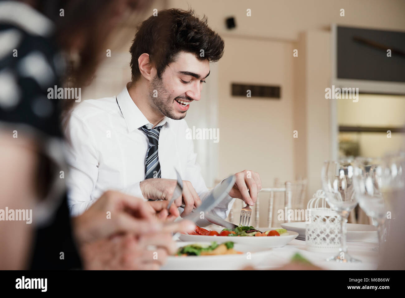 Primer plano de los invitados a la boda hablando mientras disfruta el motor de arranque de su comida en una boda. Foto de stock