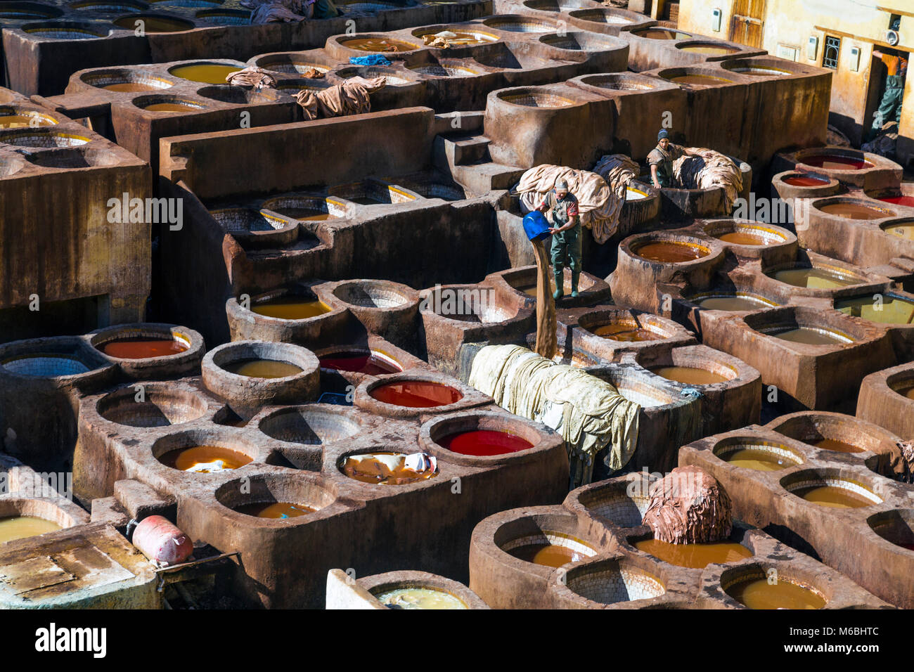 Artesanos de cuero teñido en Chaouwara curtiduría en Fez, Marruecos Foto de stock