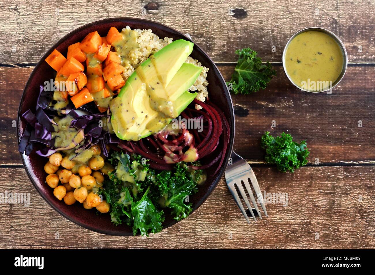 Tazón de Buda con quinoa, aguacate, garbanzos, verduras sobre un fondo de madera, el concepto de alimentos saludables. Vista desde arriba. Foto de stock