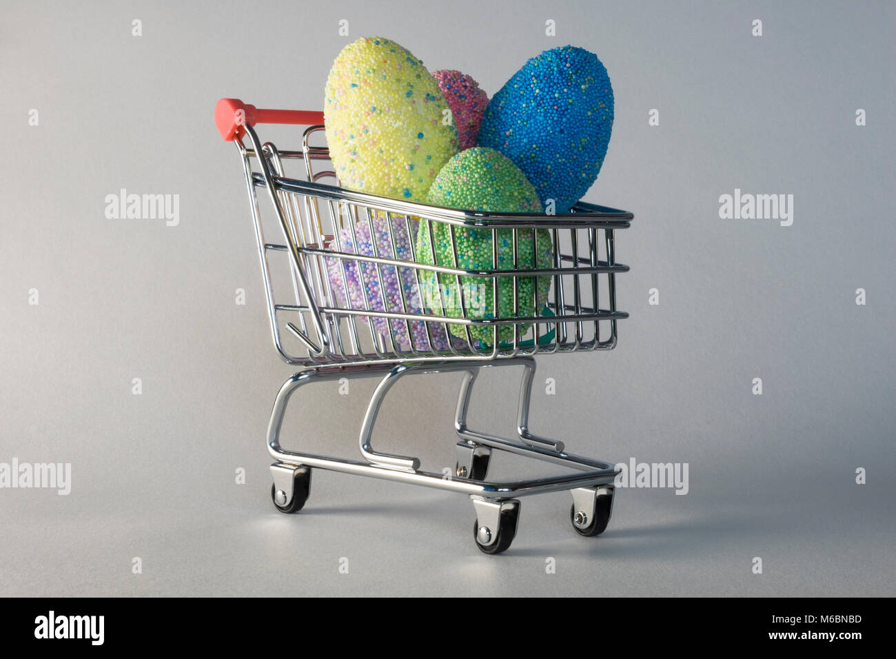 Los huevos de Pascua - coloridos huevos de chocolate multicolor en carrito o cesta para regalos de Pascua. Indica el costo y la comercialización de la Pascua celebr Foto de stock