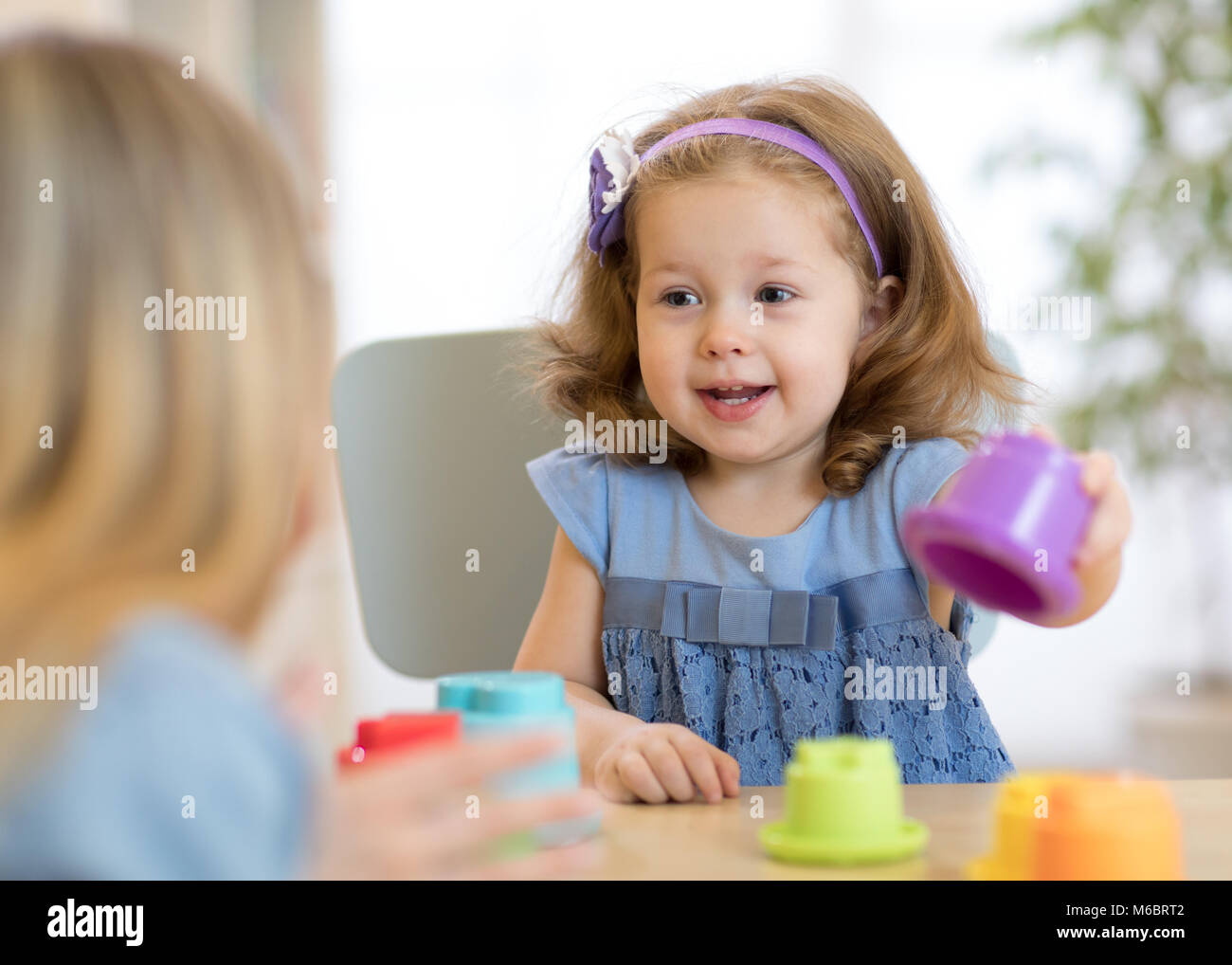 2 años de edad niña jugando con taza juguetes educativos en
