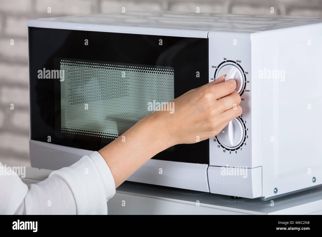 Mujer con horno microondas para calentar la comida en casa Fotografía de  stock - Alamy