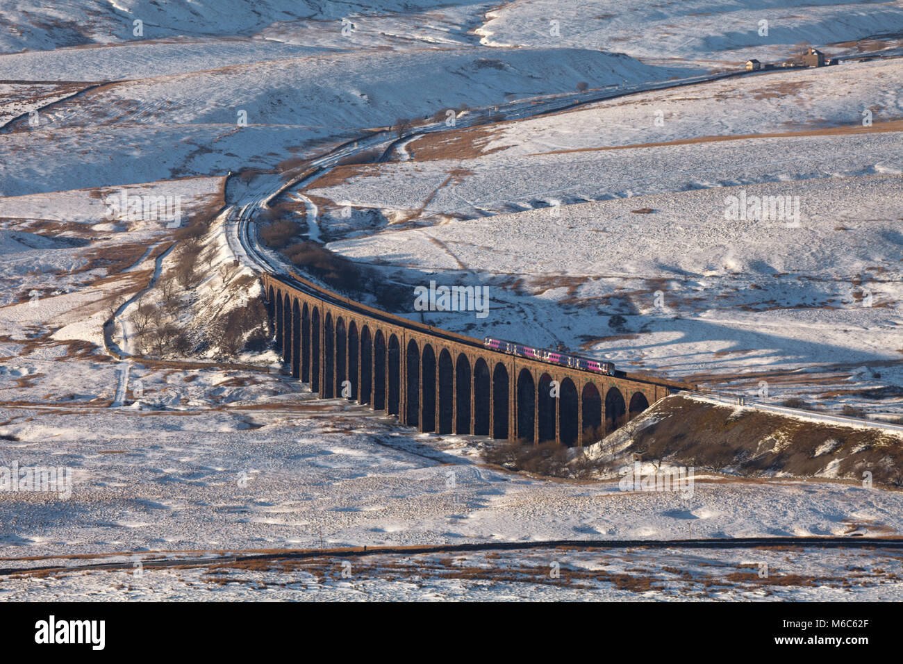 2 Northern rail express 158 clase sprinter los trenes cruzan Ribblehead viaduct, Yorkshire en el asentarse a Carlisle railway en la nieve. Foto de stock