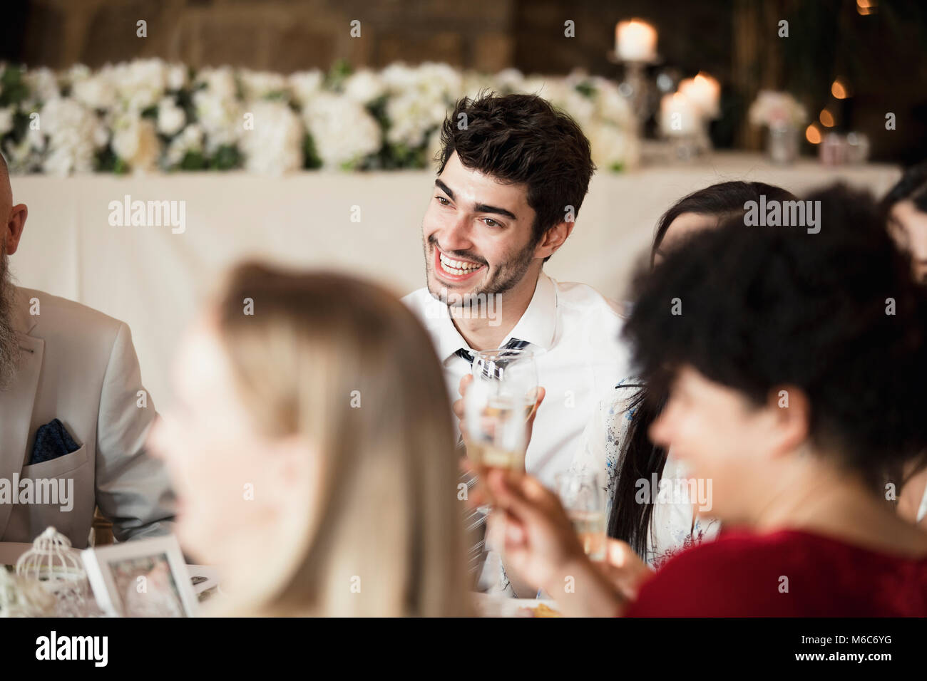 Una tabla de Felices los invitados a la boda son socializar mientras esperan los arrancadores de su comida. Foto de stock