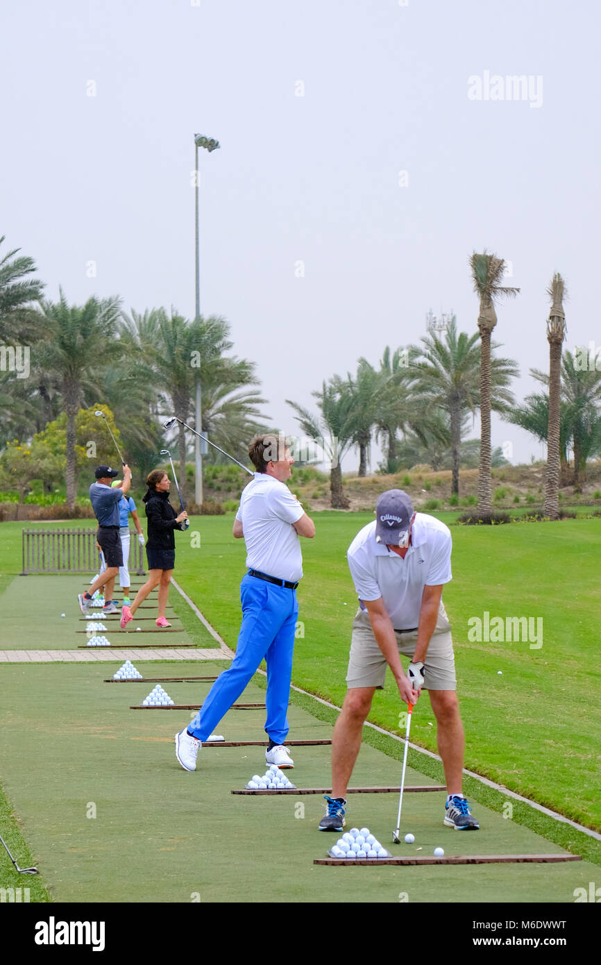 Grupo de jugadores de golf que practica en tren / Campo de Golf Playa de Saadiyat, Abu Dhabi, Emiratos Árabes Unidos. Foto de stock