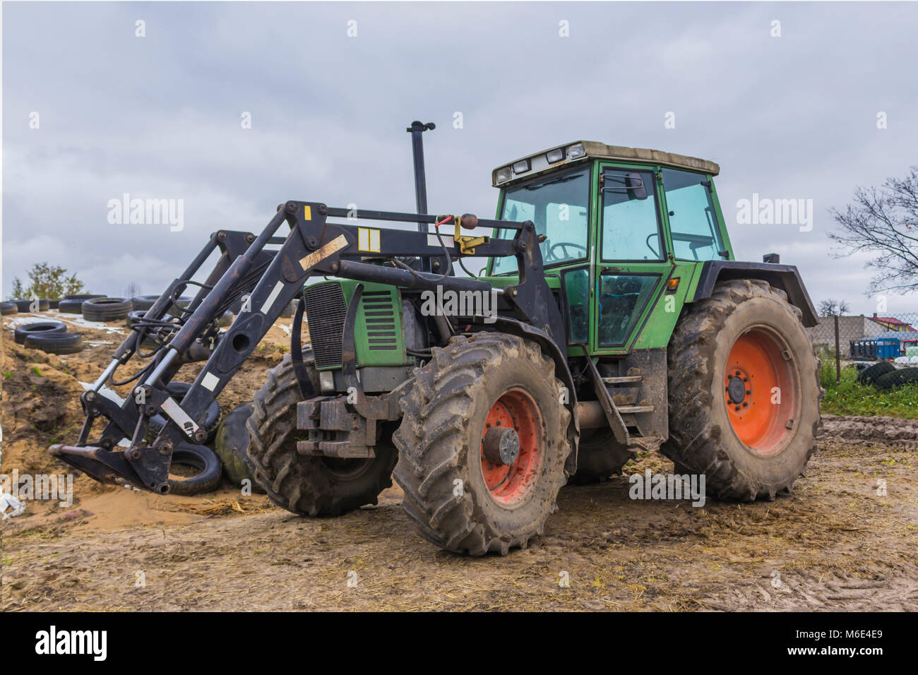 Un potente tractor diseñado para diversos trabajos en una granja agrícola. Cabina cerrada, ruedas de color rojo. A finales de otoño. Podlasie, Polonia. Foto de stock