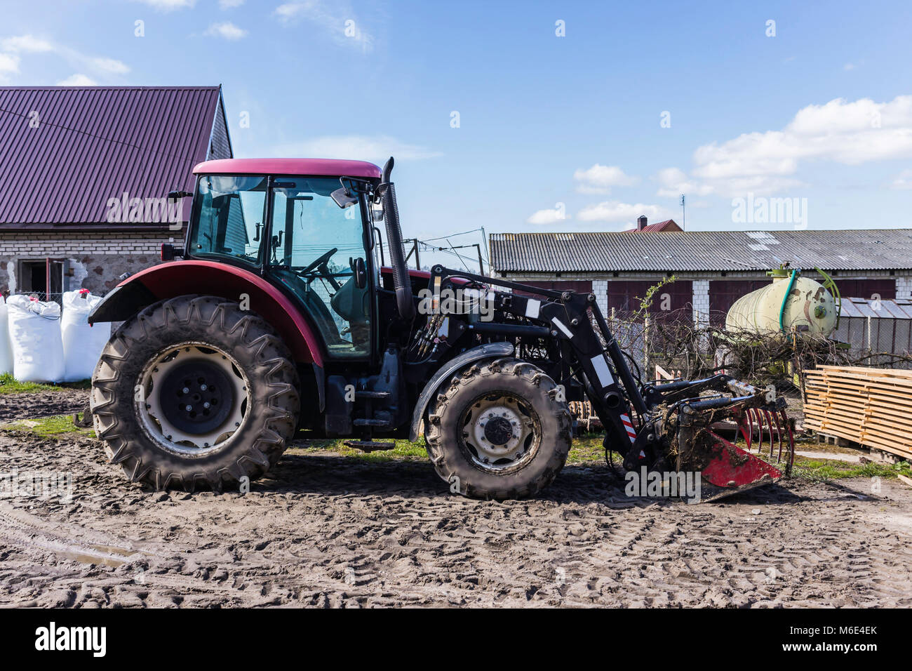 Maquinaria y equipo agrícola. Tractor con pala cargadora frontal para el  estiércol. El patio de una granja lechera. Podlaskie, Polonia Fotografía de  stock - Alamy