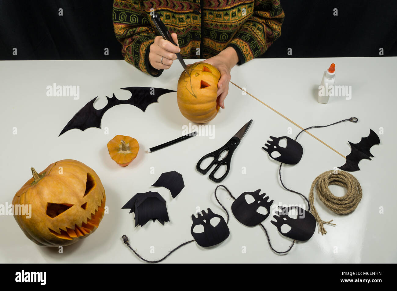 Hacer adornos de Halloween incluyendo figuras de papel, cráneos y cortando caras tenebrosas de calabazas Fotografía de stock - Alamy Hacer adornos de Halloween incluyendo figuras de papel, cráneos y cortando caras tenebrosas de calabazas Fotografía de stock - Alamy