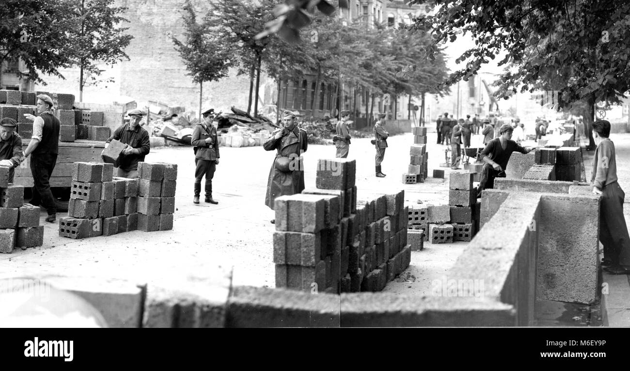 La construcción del muro de Berlín bajo la vigilancia de guardias armados, Berlín, Alemania, 1961. Foto de stock