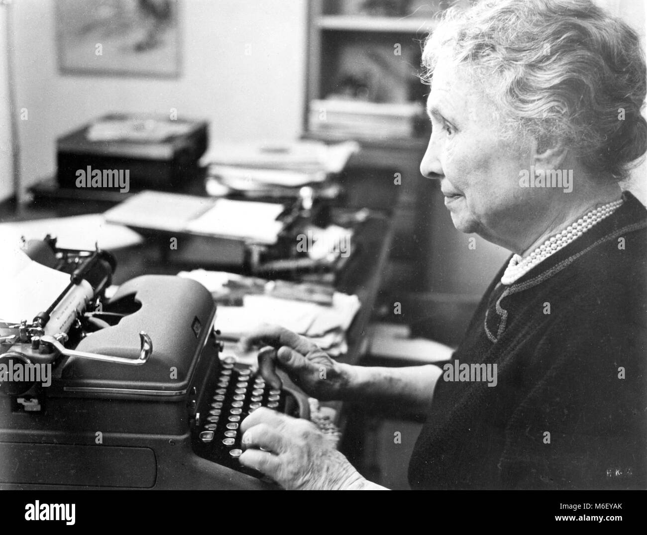 Autor Helen Keller con su máquina de escribir en su casa, en Connecticut, en 1954. Foto de stock