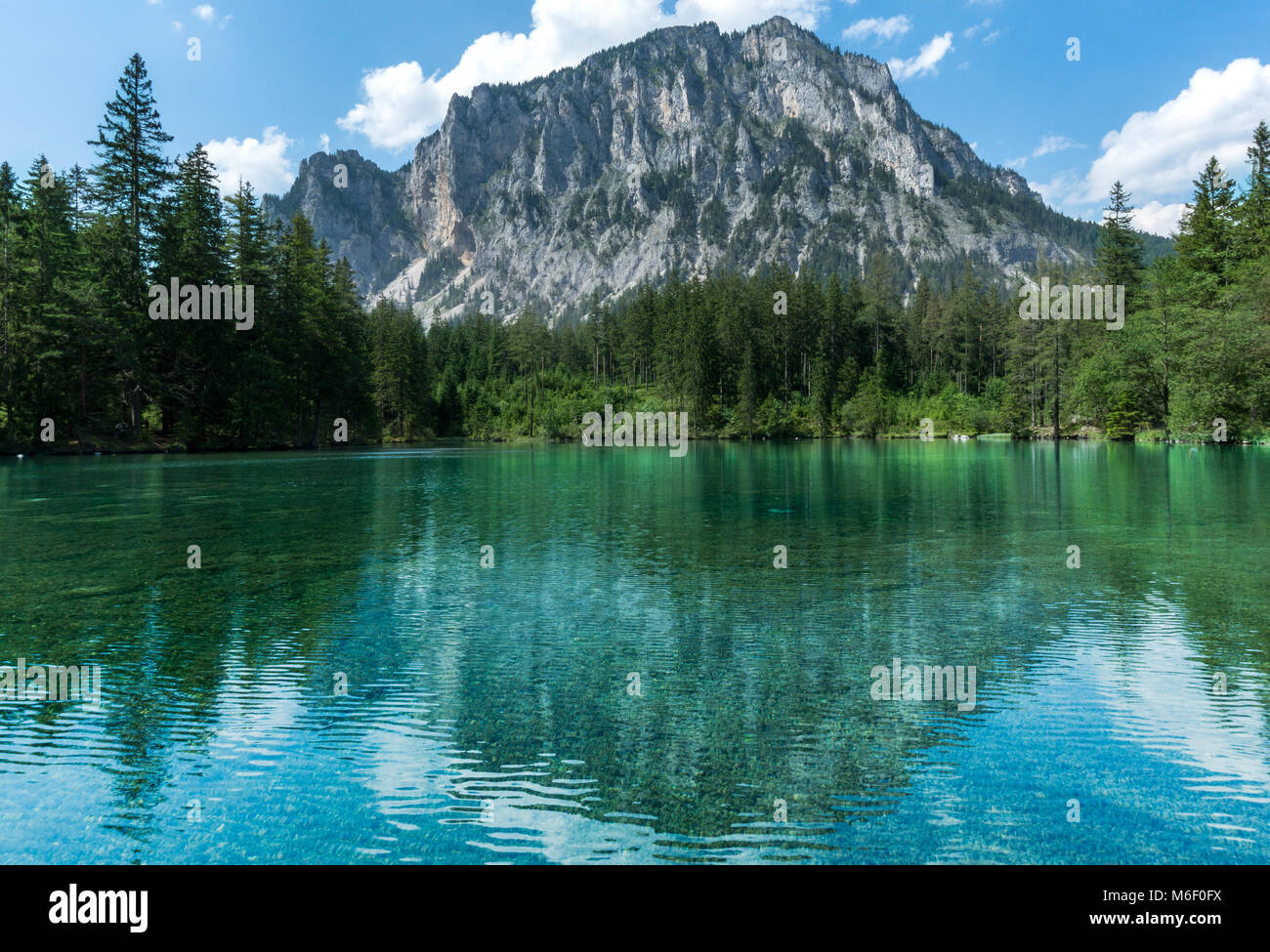 Imagen perfecta lago alpino reflejando una imponente montaña al fondo, en un soleado día de verano Foto de stock
