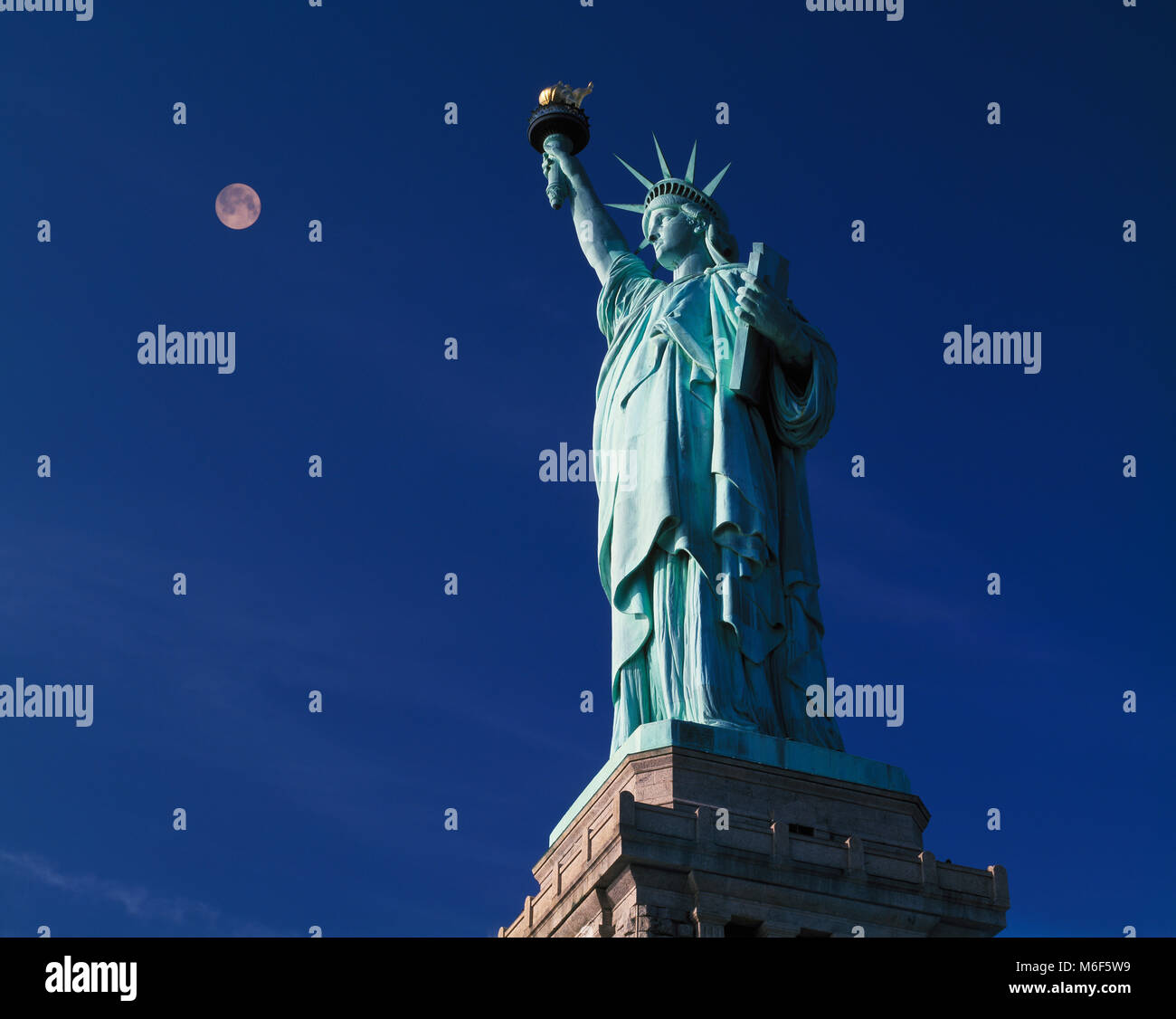 La estatua de la libertad y la luna llena al atardecer ,Liberty Island, Nueva York, EE.UU. Foto de stock