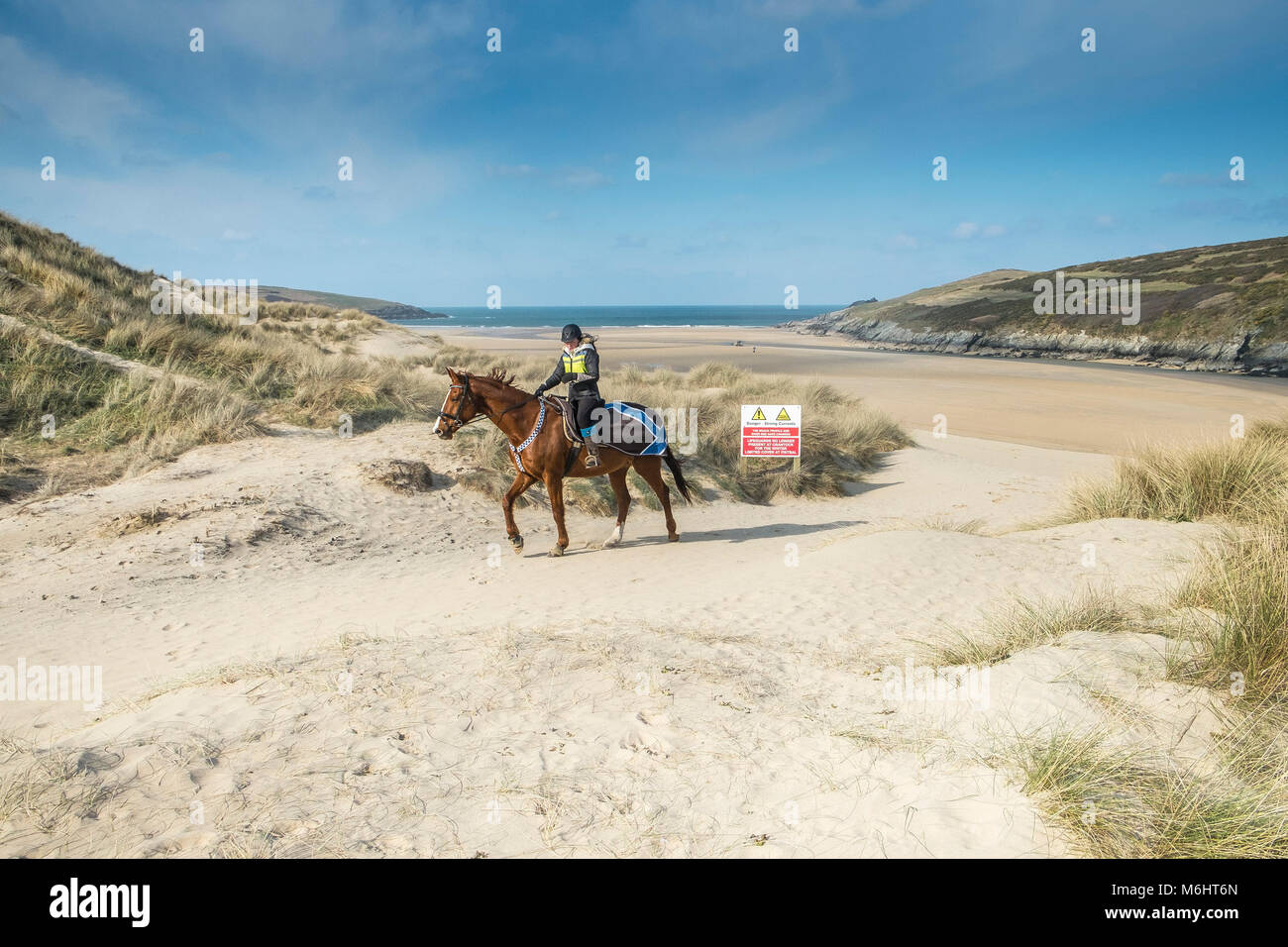 Un jinete sobre las dunas de arena en la playa Crantock en Newquay, Cornwall. Foto de stock
