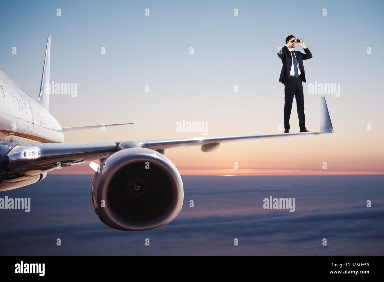 Empresario con binoculares sobre un avión busca nuevas oportunidades de negocio Foto de stock