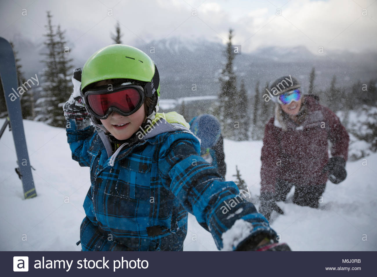 Retrato de niño travieso esquiador lanzando bolas de nieve Foto de stock