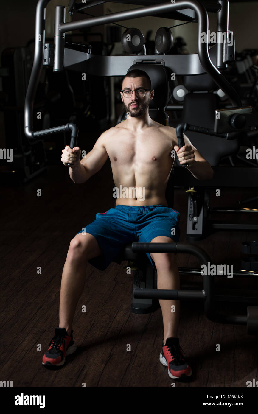 Apuesto Hombre con gafas de Fitness Muscular haciendo ejercicio