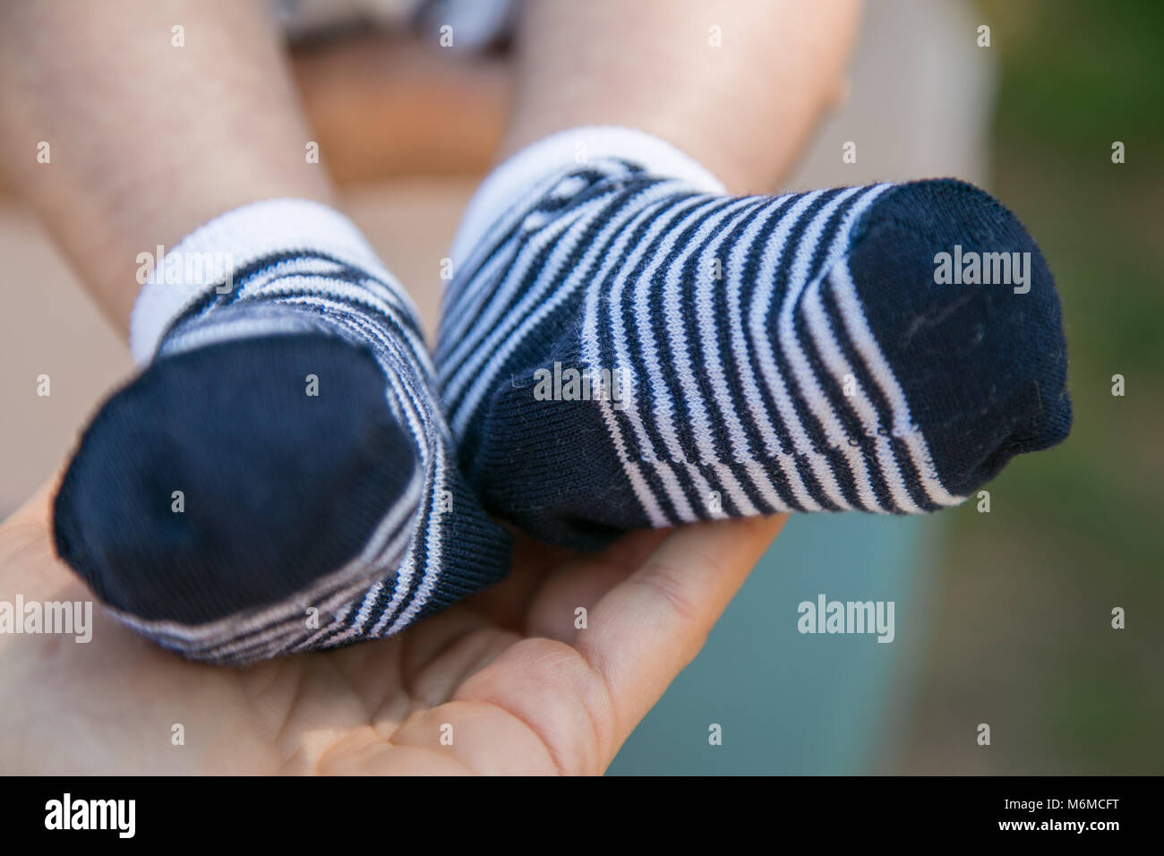 Detalle de los pies del niño, con calcetines blancos y azules, en la mano  de su abuela Fotografía de stock - Alamy