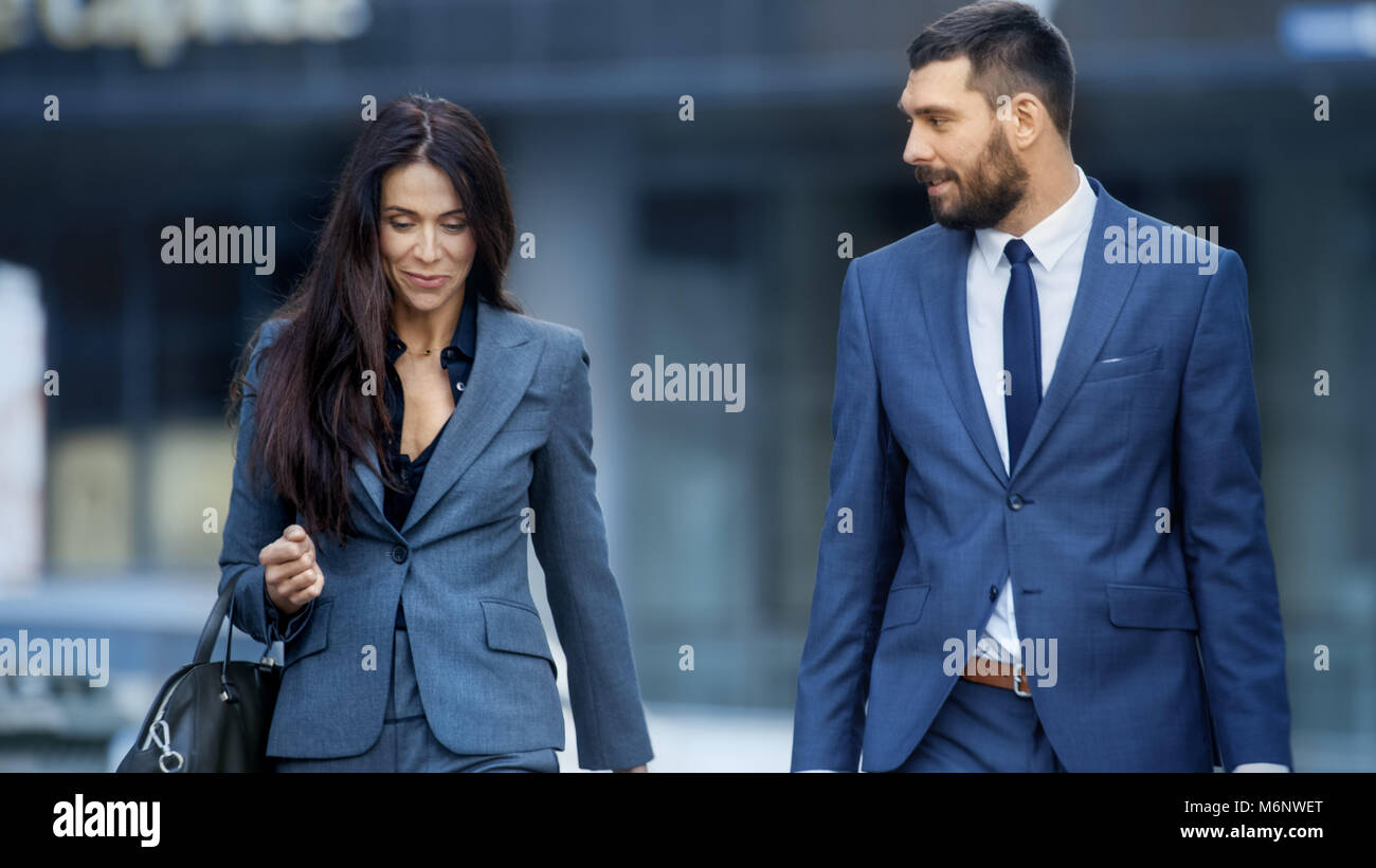 Mujer de negocios y hombres de negocios en trajes a medida a pie de la  concurrida calle de la ciudad grande Fotografía de stock - Alamy
