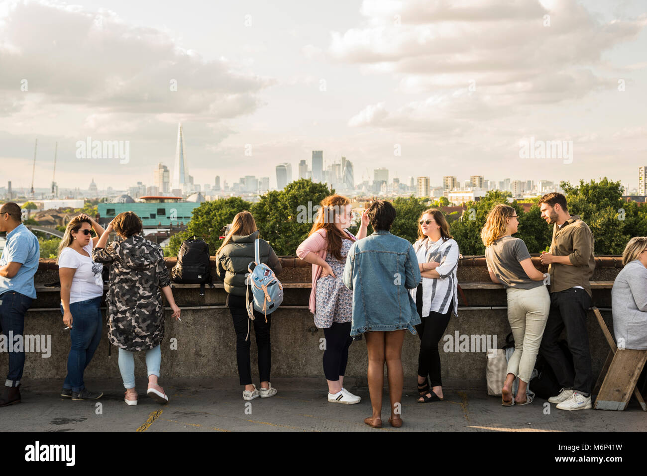 La gente socializar y disfrutar de una bebida junto a Franks cafetería piscina bar en la azotea con vistas de la ciudad. Foto de stock