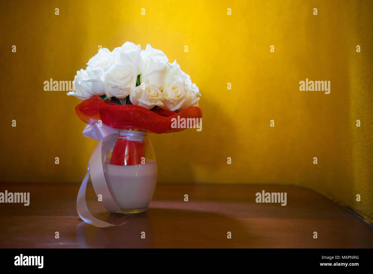 El ramo de la novia con crema de rosas y la novia zapatos, sobre el piso de  madera con fondo amarillo, la luz de arriba Fotografía de stock - Alamy