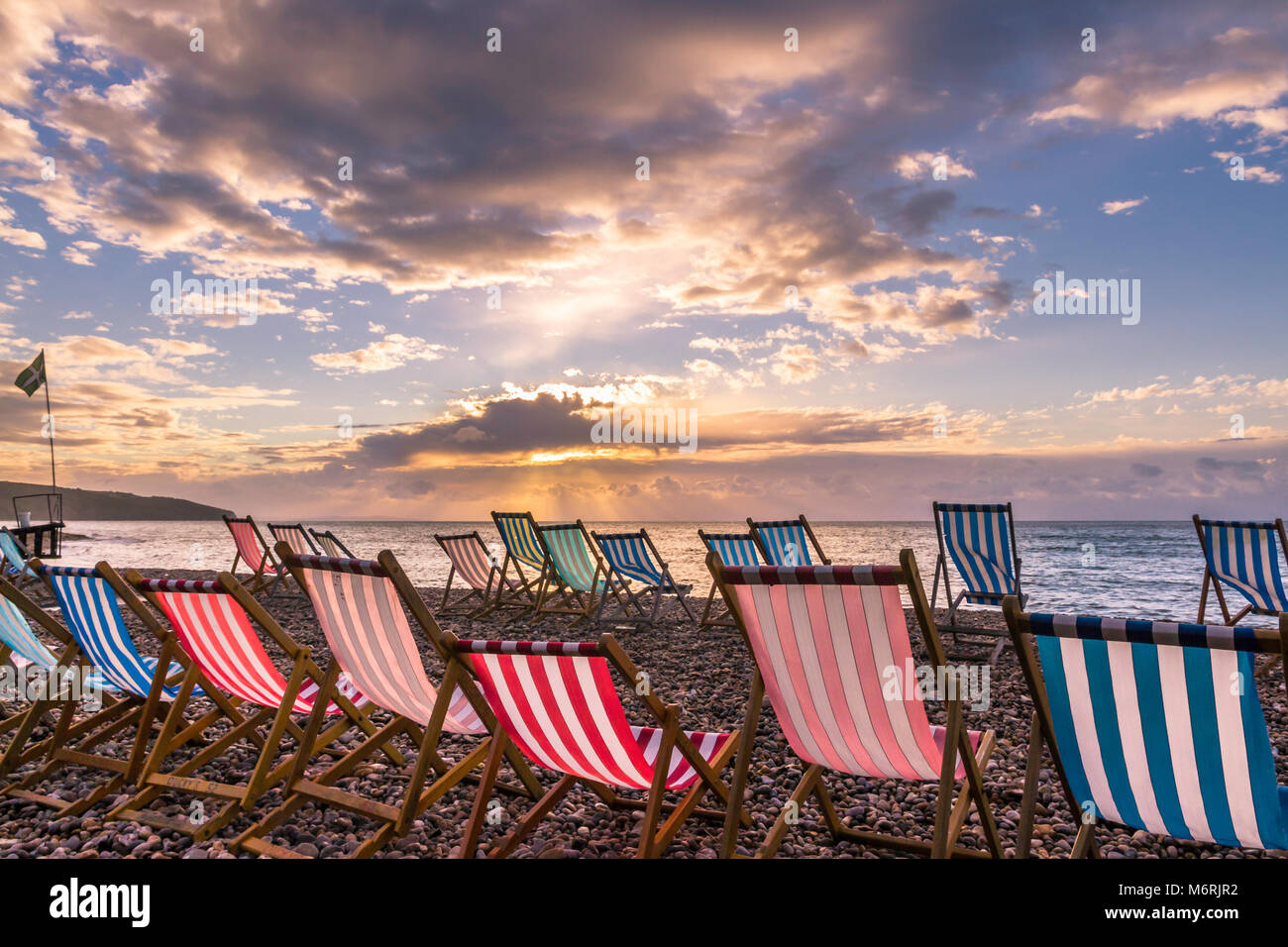 Tumbonas vacías al amanecer en la playa en cerveza, Devon. Foto de stock