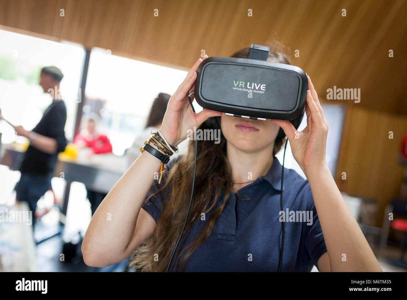 Una mujer usa un auricular VR Foto de stock