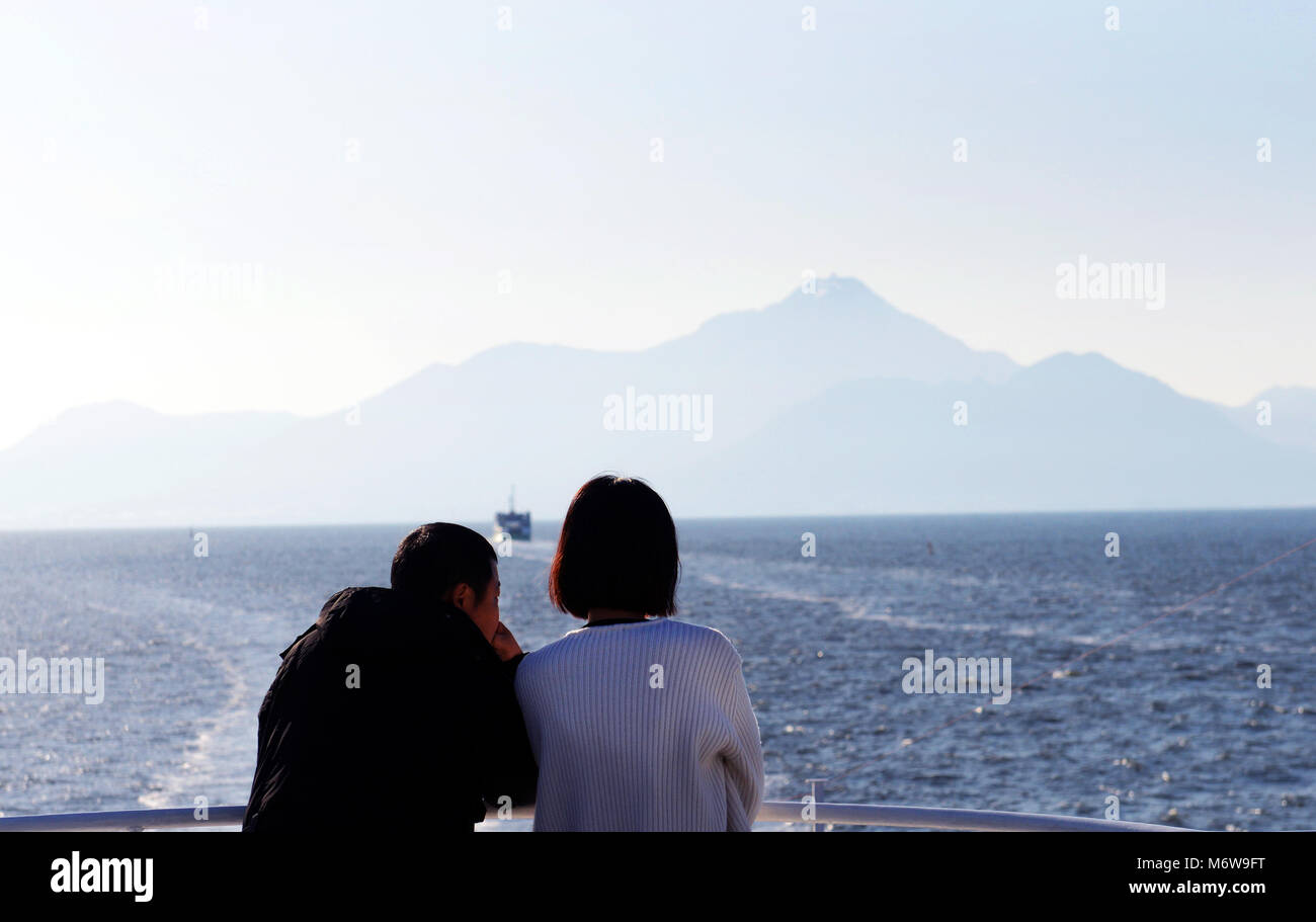 Una pareja de pie en el ferry en la bahía de Shimabara conectando Shimabara y Kumamoto. Foto de stock