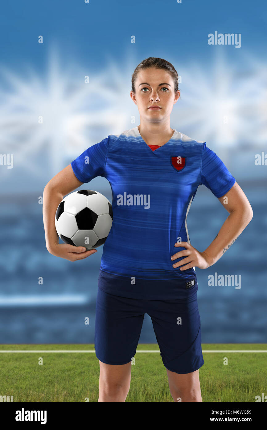 Retrato del jugador de fútbol femenino sosteniendo la pelota con stadium en segundo plano. Foto de stock