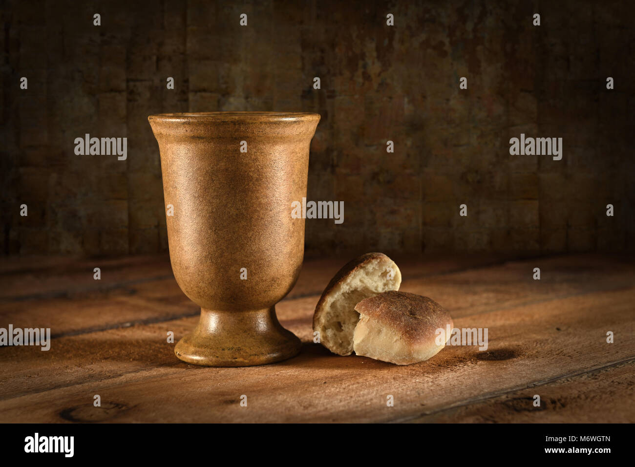 Copa de vino y pan como símbolos de la comunión en la mesa de madera Foto de stock