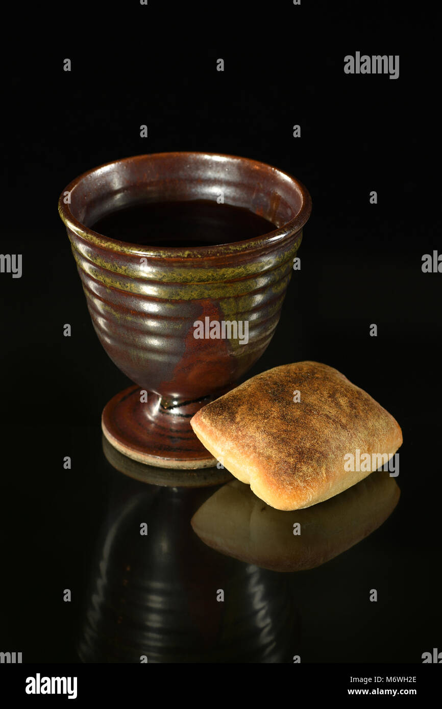 Copa de vino y pan en la mesa sobre fondo oscuro Foto de stock
