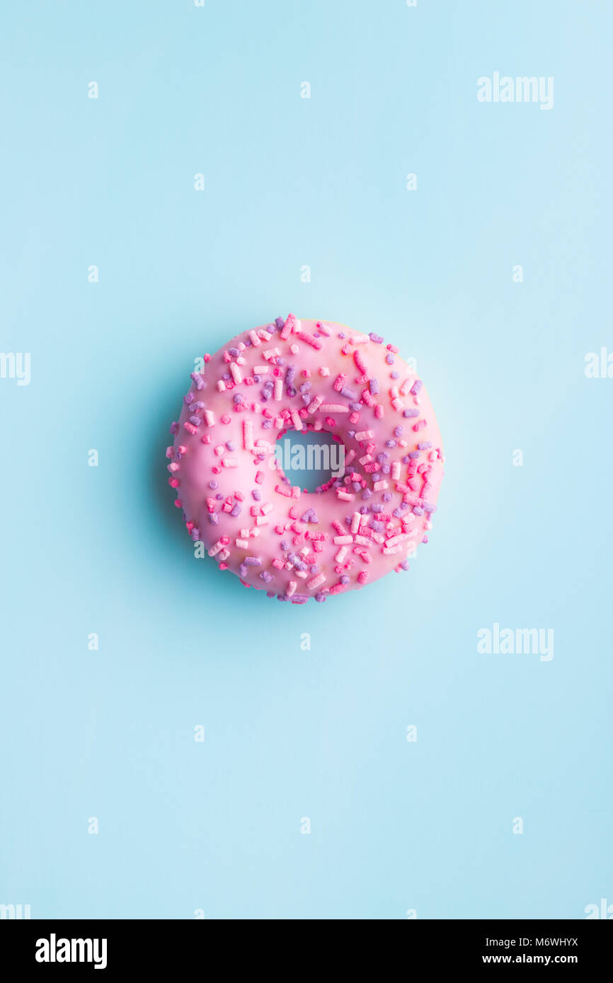 Un donut rosa sobre fondo azul. Foto de stock