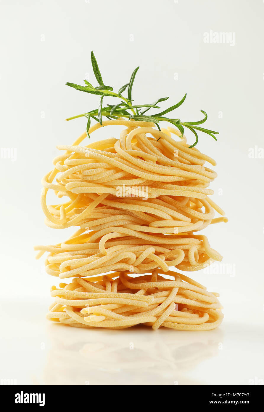 Paquetes de espaguetis sin cocer la pasta sobre fondo blanco. Foto de stock