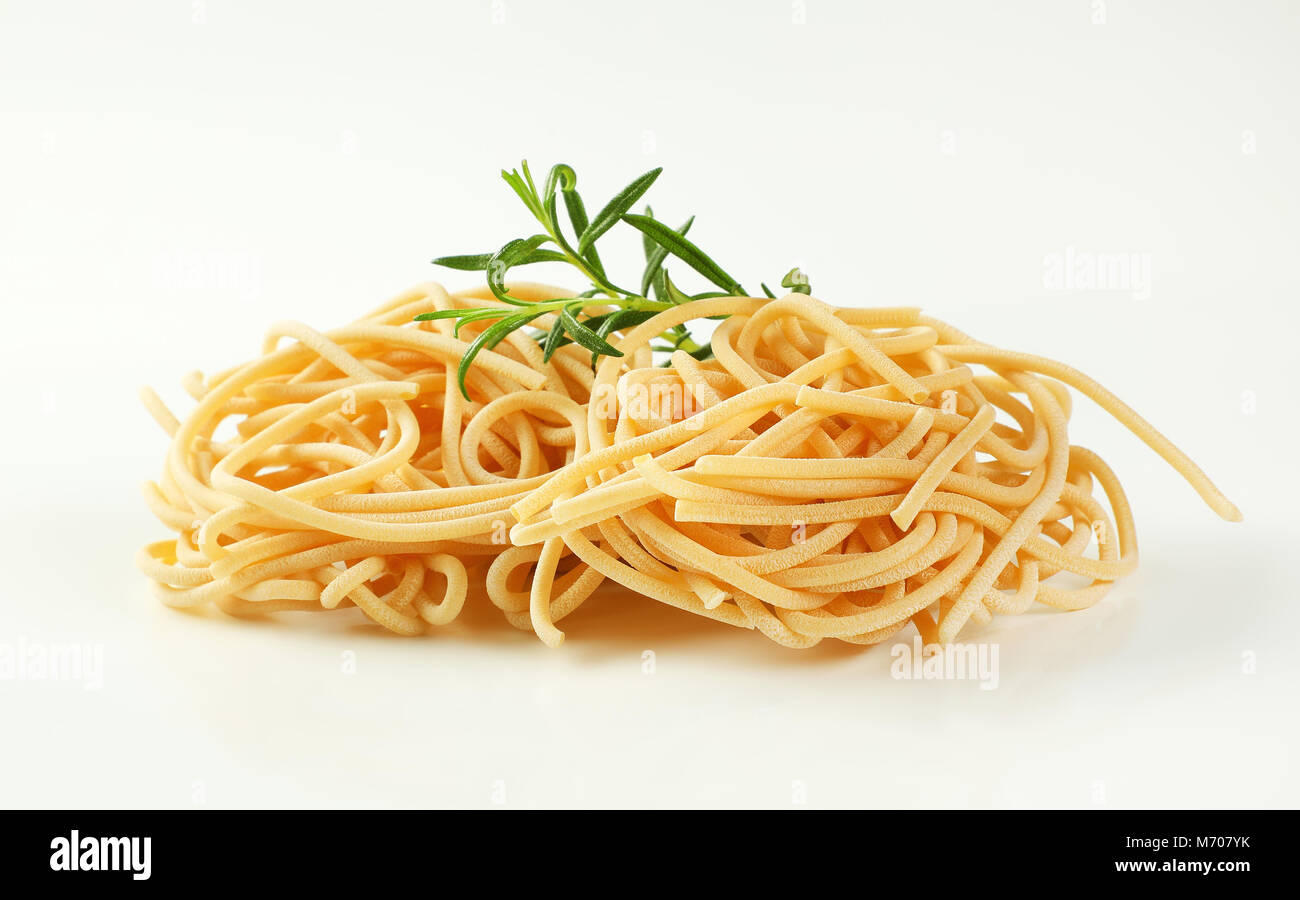 Paquetes de espaguetis sin cocer la pasta sobre fondo blanco. Foto de stock